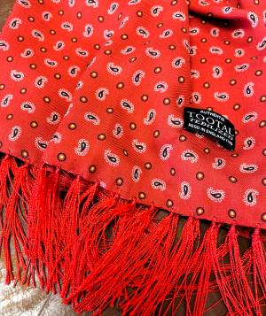 Tootal red rayon scarf with a traditional paisley print and soft fringed ends, made from lightweight double-faced fabric.