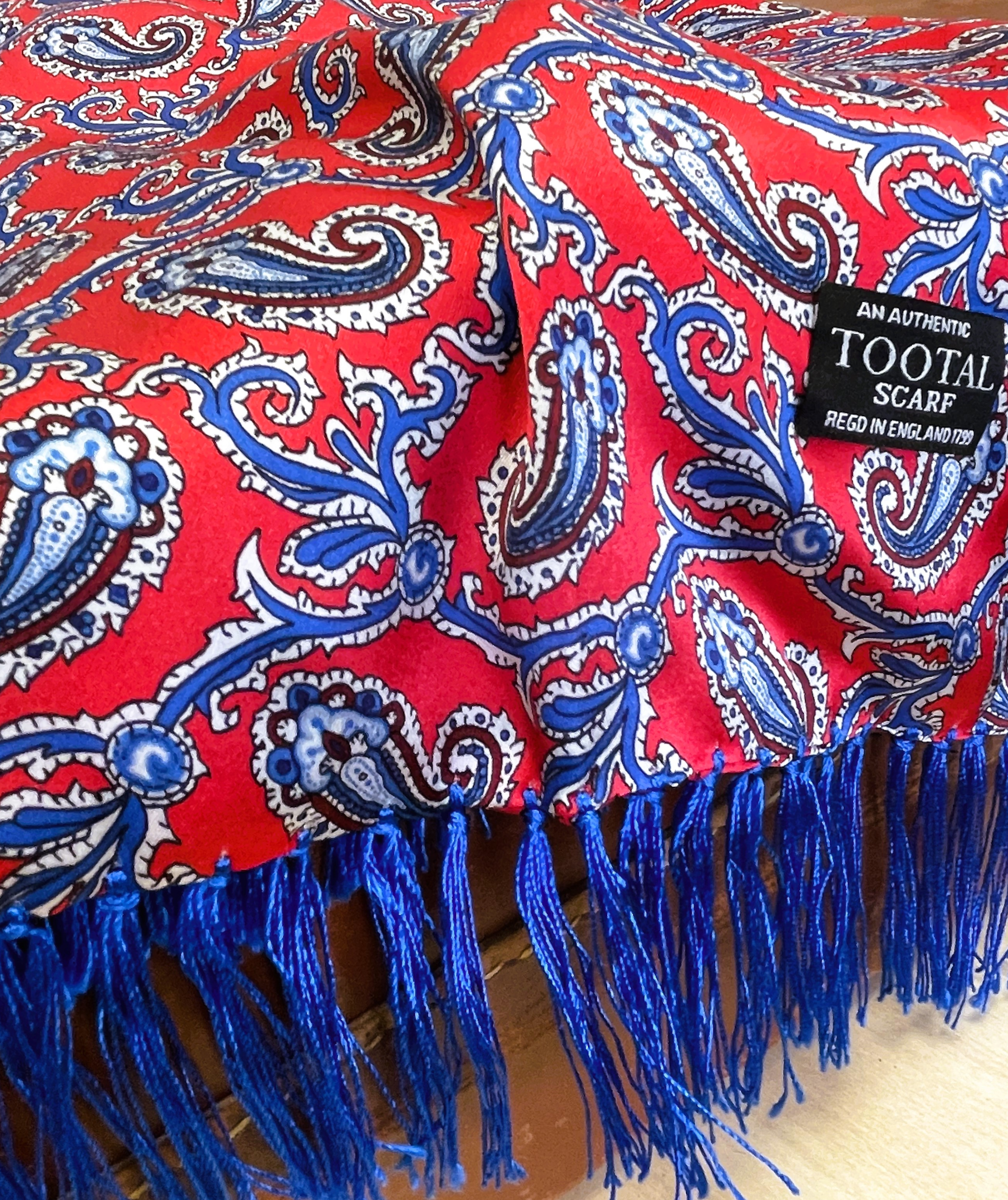 Tootal barberry red silk scarf with traditional paisley pattern and tassel ends, made from 100% silk.