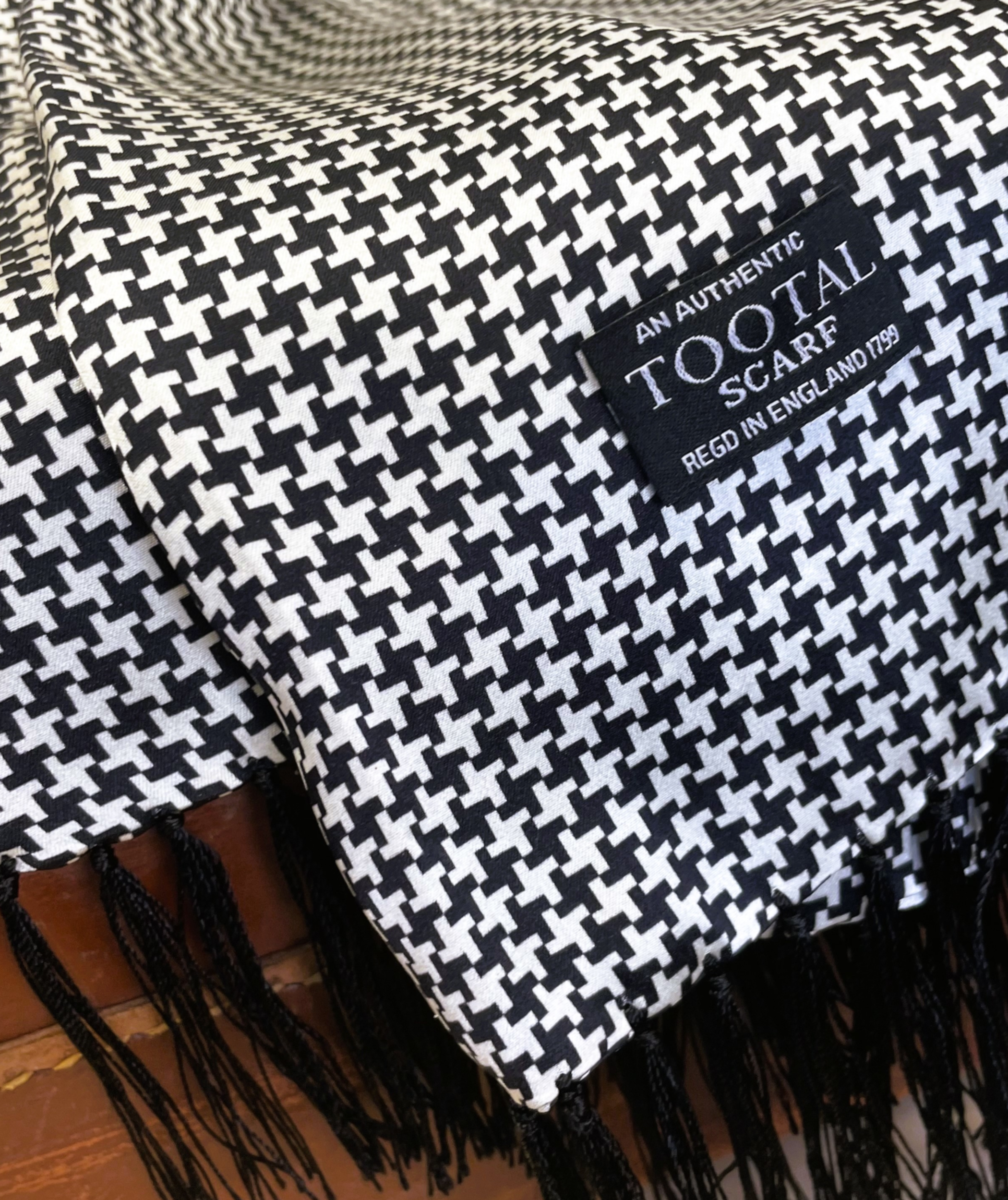 Black and white Tootal silk scarf with bold dogtooth pattern and fringe ends, made from 100% pure silk.